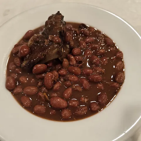 Plato hondo de alubias rojas guisadas con sus sacramentos.