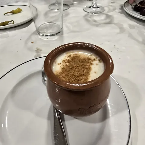 Cazuela de barro con arroz con leche y canela por encima.